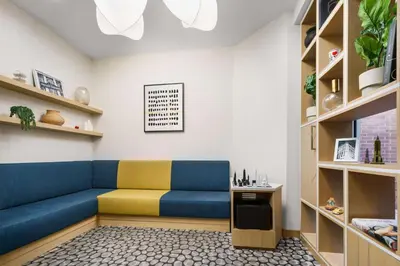 a living room with a blue couch and shelves at Hampton Inn Manhattan-35th St Empire State Bldg in New York