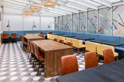 a dining room with tables and chairs and a mural at Hampton Inn Manhattan-35th St Empire State Bldg in New York