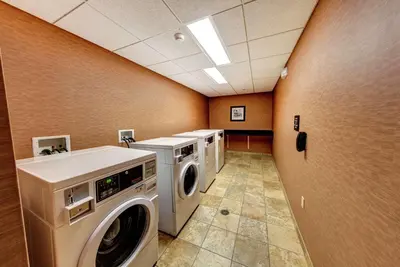 a laundry room with three washing machines in it at Hampton Inn & Suites Chadds Ford in Glen Mills