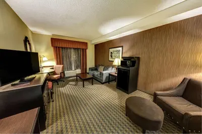 a hotel room with a couch and a television at Hampton Inn & Suites Chadds Ford in Glen Mills