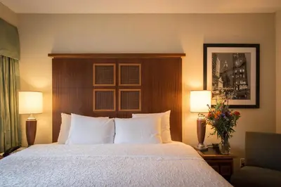 a hotel room with a bed with two lamps and flowers at SoHo 54 in New York