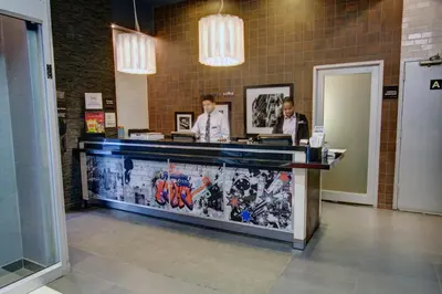 two men standing at a counter in a lobby at SoHo 54 in New York