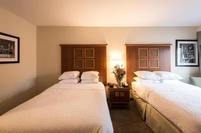 two beds in a hotel room with flowers on a table at SoHo 54 in New York