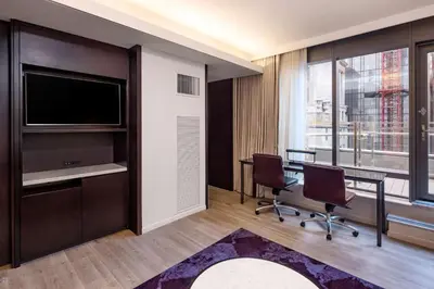 a room with a tv and two chairs and a table at Hilton Club West 57th Street New York in New York