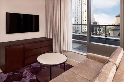 a living room with a couch and a large window at Hilton Club West 57th Street New York in New York