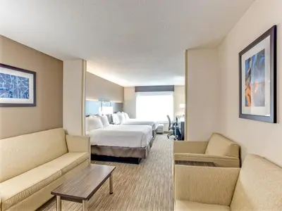 a hotel room with a bed and two chairs at Holiday Inn Express Hotel & Suites Bethlehem by IHG in Bethlehem