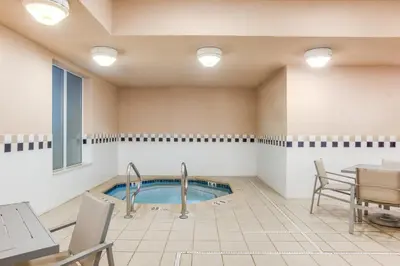a pool in a room with a table and chairs at Holiday Inn Express Hotel & Suites Bethlehem by IHG in Bethlehem