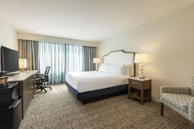 a hotel room with a bed and a desk and chair at Embassy Suites by Hilton Philadelphia Valley Forge in Wayne