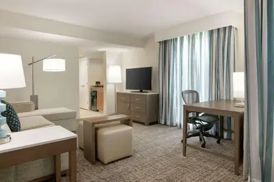 a hotel room with a desk and a living room at Embassy Suites by Hilton Philadelphia Valley Forge in Wayne