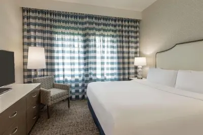 a hotel room with a bed and a chair at Embassy Suites by Hilton Philadelphia Valley Forge in Wayne