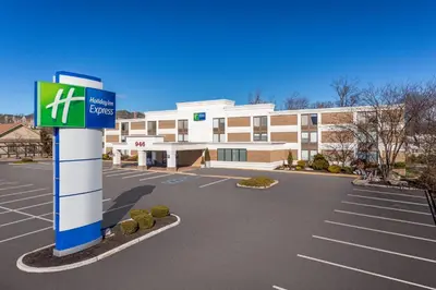 a building with a sign in front of a parking lot at Holiday Inn Express Ramsey Mahwah by IHG in Ramsey