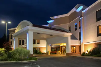 a large white building with a parking lot at night at Holiday Inn Express Lewisburg - New Columbia by IHG in New Columbia