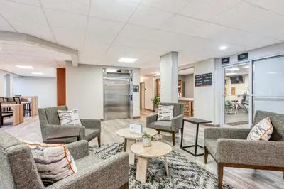 a waiting room with couches and chairs and tables at Candlewood Suites Bordentown-Trenton by IHG in Bordentown