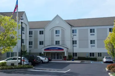 a large white building with cars parked in a parking lot at Candlewood Suites Bordentown-Trenton by IHG in Bordentown