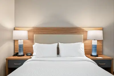 a bedroom with a large bed with two lamps at Candlewood Suites Bordentown-Trenton by IHG in Bordentown