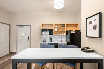 a kitchen with a table and chairs in a room at Candlewood Suites Bordentown-Trenton by IHG in Bordentown