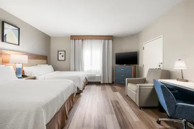 a hotel room with two beds and a flat screen tv at Candlewood Suites Bordentown-Trenton by IHG in Bordentown