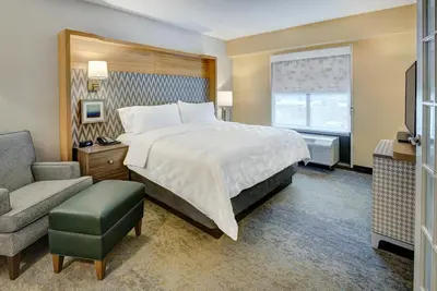 a hotel room with a bed and a chair at Holiday Inn East Windsor by IHG in Hightstown