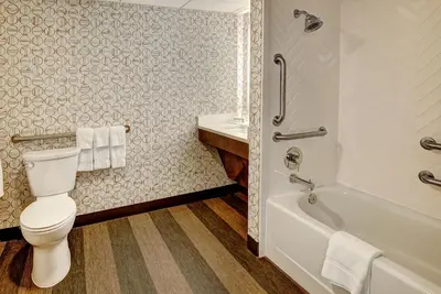 a bathroom with a toilet and a tub and a sink at Holiday Inn East Windsor by IHG in Hightstown