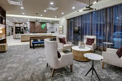 a living room with chairs and a table at Holiday Inn East Windsor by IHG in Hightstown