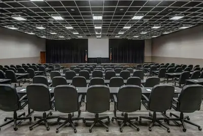 an empty conference room with chairs and a screen at Holiday Inn East Windsor by IHG in Hightstown