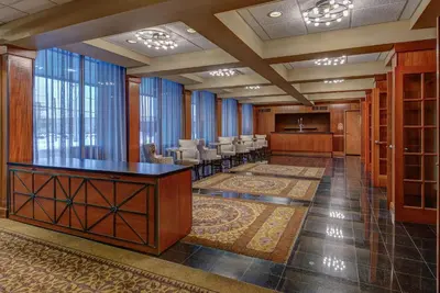 a large lobby with a waiting room with tables and chairs at Holiday Inn East Windsor by IHG in Hightstown