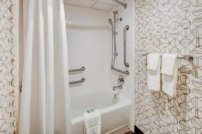 a bathroom with a white shower curtain and a tub at Holiday Inn East Windsor by IHG in Hightstown