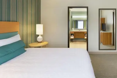 a hotel room with a bed and a mirror at Home2 Suites by Hilton Downingtown Exton Route 30 in Downingtown