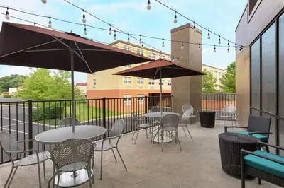 a patio with tables and chairs and umbrellas at Home2 Suites by Hilton Downingtown Exton Route 30 in Downingtown