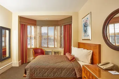 a bedroom with a bed and a desk with a phone at Alexander Inn in Philadelphia