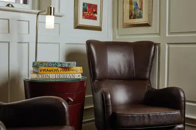 a brown chair sitting next to a stack of books at Alexander Inn in Philadelphia