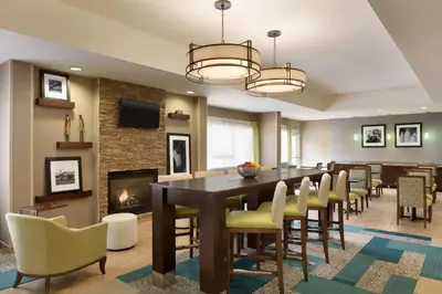 a dining room with a table and chairs and a fireplace at Hampton Inn Denville-Rockaway-Parsippany in Denville