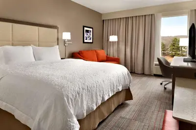 a hotel room with a large bed and a desk at Hampton Inn Denville-Rockaway-Parsippany in Denville
