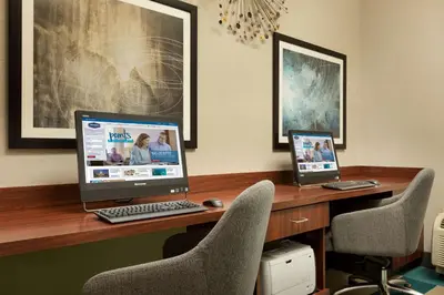 a desk with two computers sitting on top of it at Hampton Inn Denville-Rockaway-Parsippany in Denville