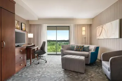 a hotel room with a couch and a desk and a television at Courtyard by Marriott Philadelphia Montgomeryville in North Wales