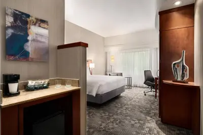 a hotel room with a bed and a living room at Courtyard by Marriott Philadelphia Montgomeryville in North Wales