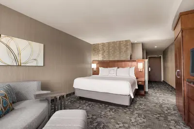 a hotel room with a bed and a couch at Courtyard by Marriott Philadelphia Montgomeryville in North Wales