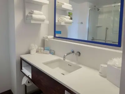 a bathroom with a sink and a mirror and towels at Hampton Inn Hazleton in Hazleton
