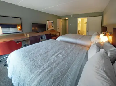 a hotel room with two beds and a television at Hampton Inn Hazleton in Hazleton