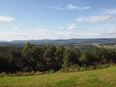 a view of a field from a hill with trees at Hampton Inn Hazleton in Hazleton