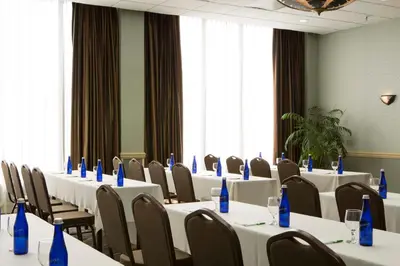 a room with tables and chairs with blue bottles on them at Holiday Inn Binghamton-Downtown Hawley Street by IHG in Binghamton
