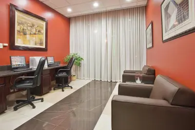 an office with orange walls and desks and chairs at Holiday Inn Binghamton-Downtown Hawley Street by IHG in Binghamton