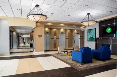 a lobby with blue chairs and a table at Holiday Inn Binghamton-Downtown Hawley Street by IHG in Binghamton