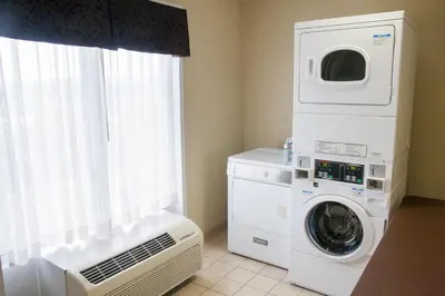 a laundry room with a washing machine and a washer at Holiday Inn Express Hotel & Suites Binghamton University-Vestal by IHG in Vestal