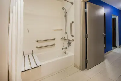 a bathroom with a bath tub with a shower curtain at Holiday Inn Express Hotel & Suites Binghamton University-Vestal by IHG in Vestal