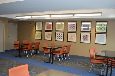 a dining room with tables and chairs and pictures on the wall at Holiday Inn Express Hotel & Suites Binghamton University-Vestal by IHG in Vestal
