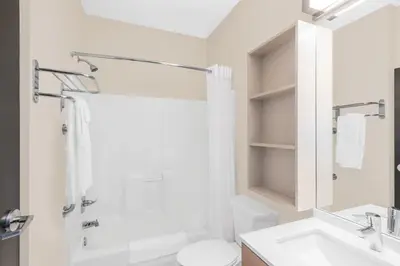 a white bathroom with a sink and a toilet at Microtel Inn & Suites by Wyndham Binghamton in Binghamton