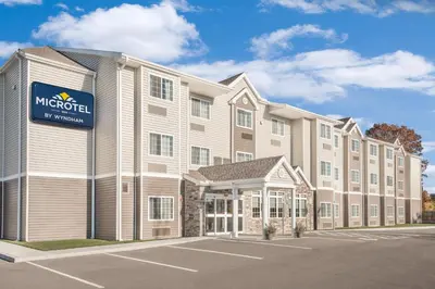 a large building with a sign on the front of it at Microtel Inn & Suites by Wyndham Binghamton in Binghamton