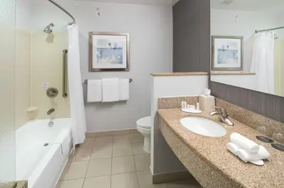 a bathroom with a sink and a toilet and a tub at Courtyard by Marriott West Orange in West Orange