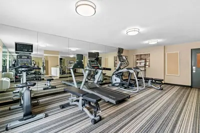 a gym with treadmills and ellipticals in a building at Candlewood Suites Hazleton by IHG in Hazleton